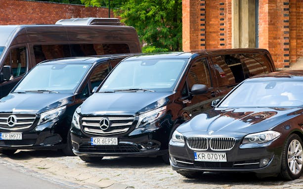 Krakow airport transfer vehicles parked near brick building.