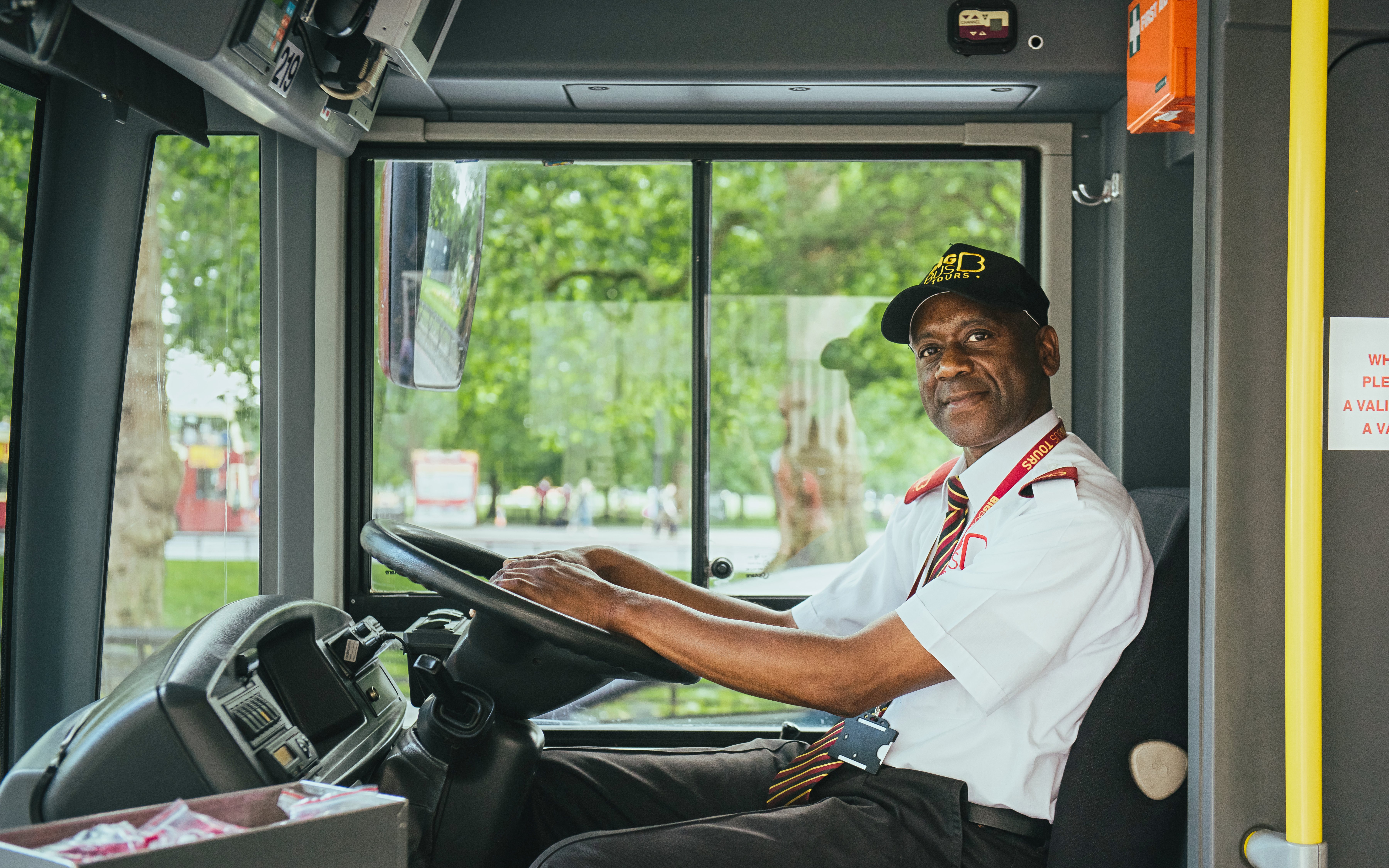 Driver on Big Bus HOHO tour in city setting.