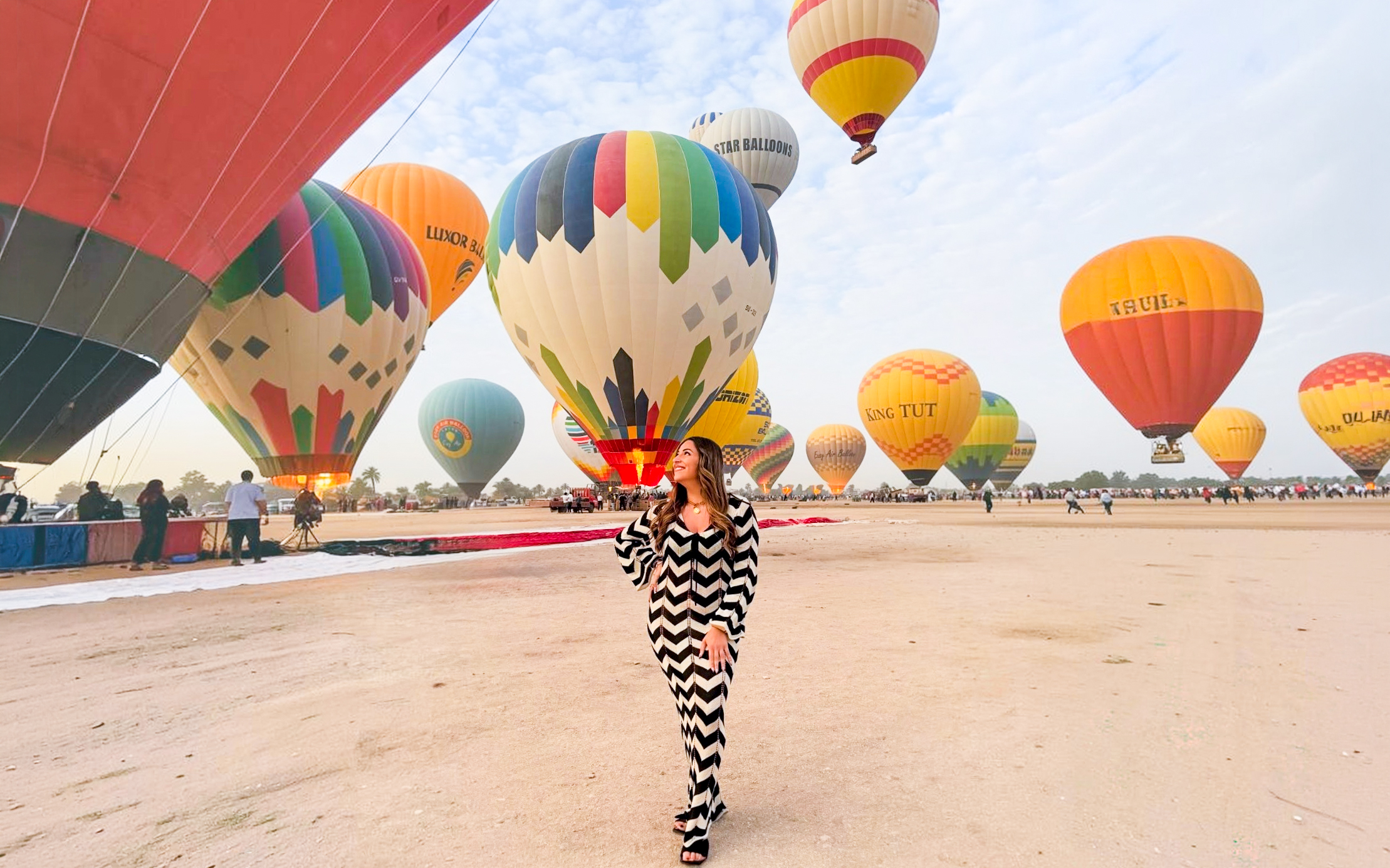 Hot air balloons preparing for flight in Luxor desert.