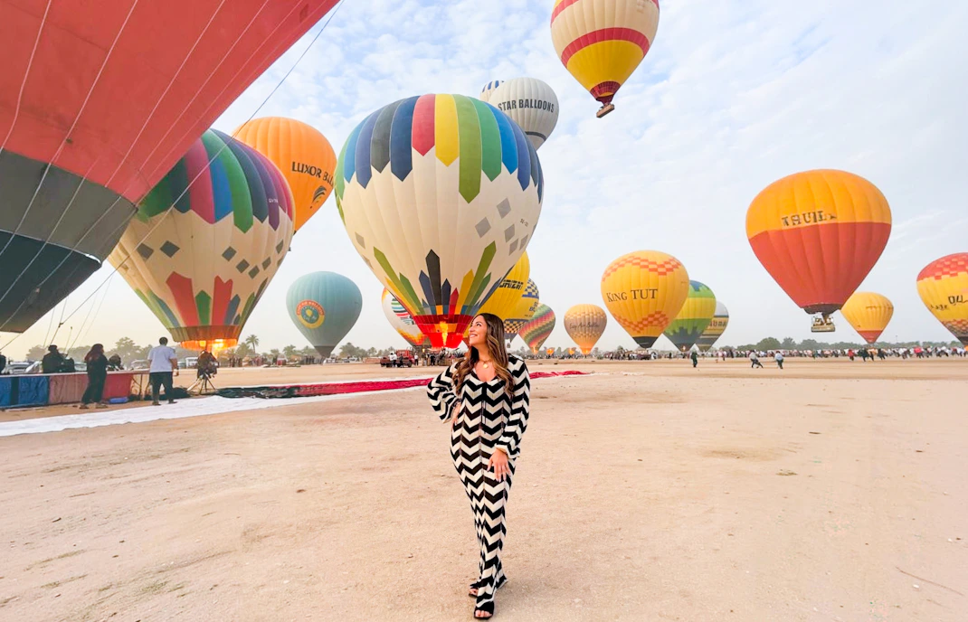 Hot air balloons preparing for flight in Luxor desert.
