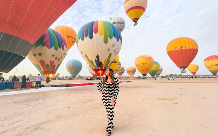 Hot air balloons preparing for flight in Luxor desert.