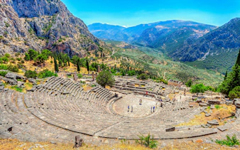 Ancient theater in Delphi, Greece with mountainous landscape, part of Athens private day trip.