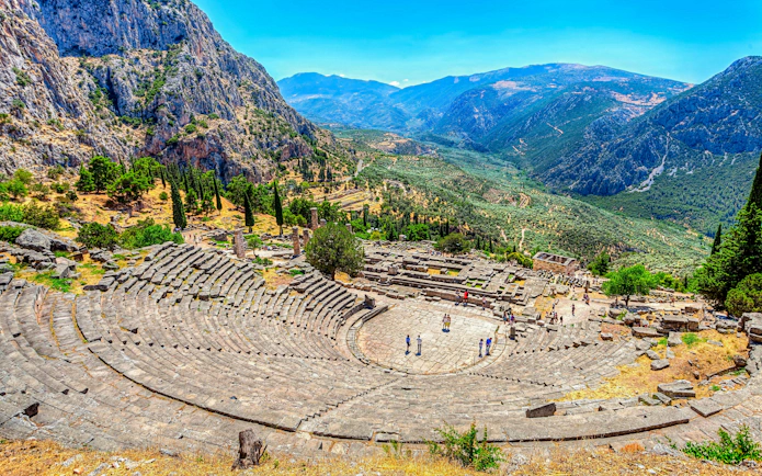 Ancient theater in Delphi, Greece with mountainous landscape, part of Athens private day trip.