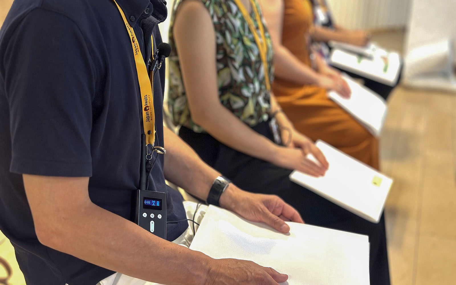Participants seated with notebooks during a sumo stable morning practice in Japan.