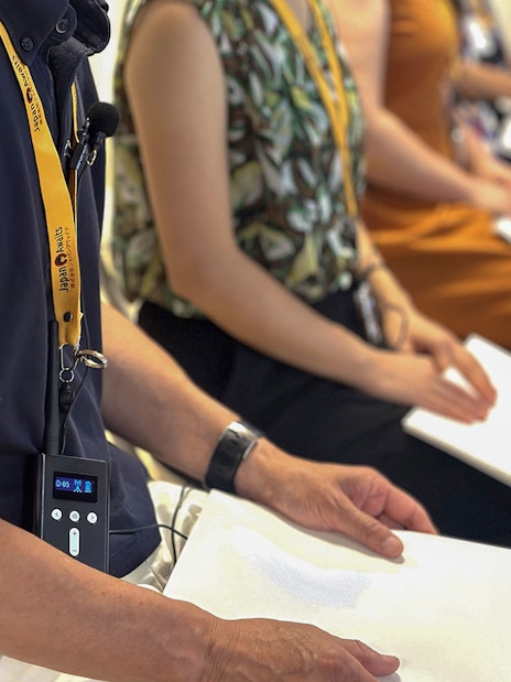 Participants seated with notebooks during a sumo stable morning practice in Japan.
