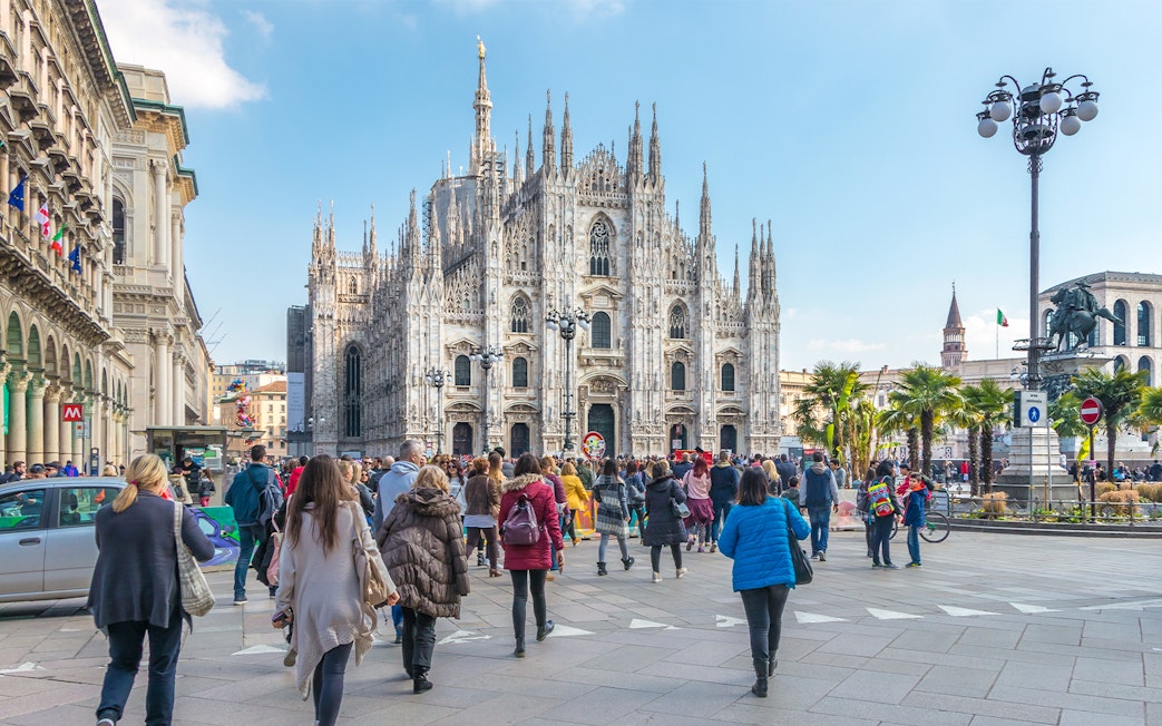 Tourists on Milan Hop-On Hop-Off Tour with Milan Duomo in the background.