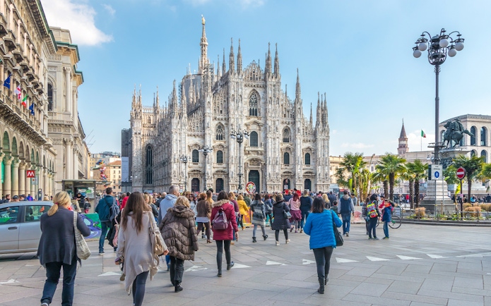 Tourists on Milan Hop-On Hop-Off Tour with Milan Duomo in the background.