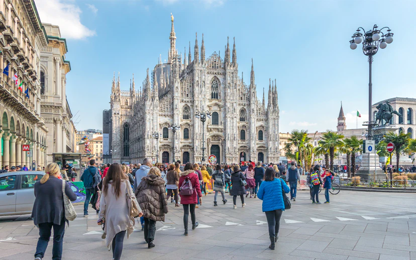Tourists on Milan Hop-On Hop-Off Tour with Milan Duomo in the background.