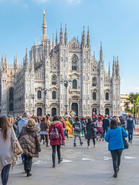 Tourists on Milan Hop-On Hop-Off Tour with Milan Duomo in the background.