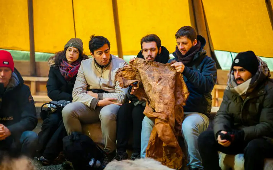 Participants learning about Sami culture in a Tromsø reindeer feeding experience.