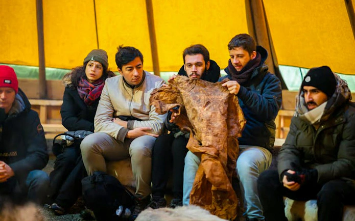 Participants learning about Sami culture in a Tromsø reindeer feeding experience.