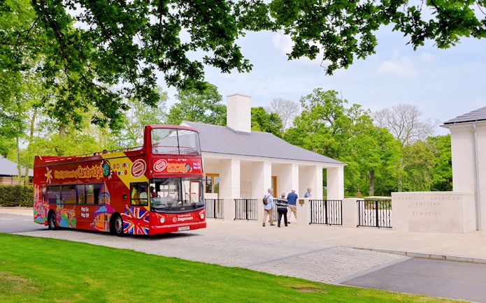Double-decker bus on Cambridge tour passing American Cemetery and Memorial.