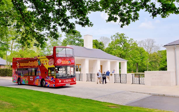 Double-decker bus on Cambridge tour passing American Cemetery and Memorial.