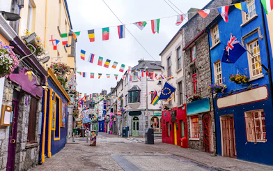 Colorful buildings and international flags on Galway City's main street.