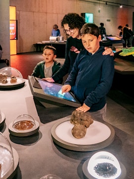 Visitors exploring interactive exhibits at Espai Crater museum.