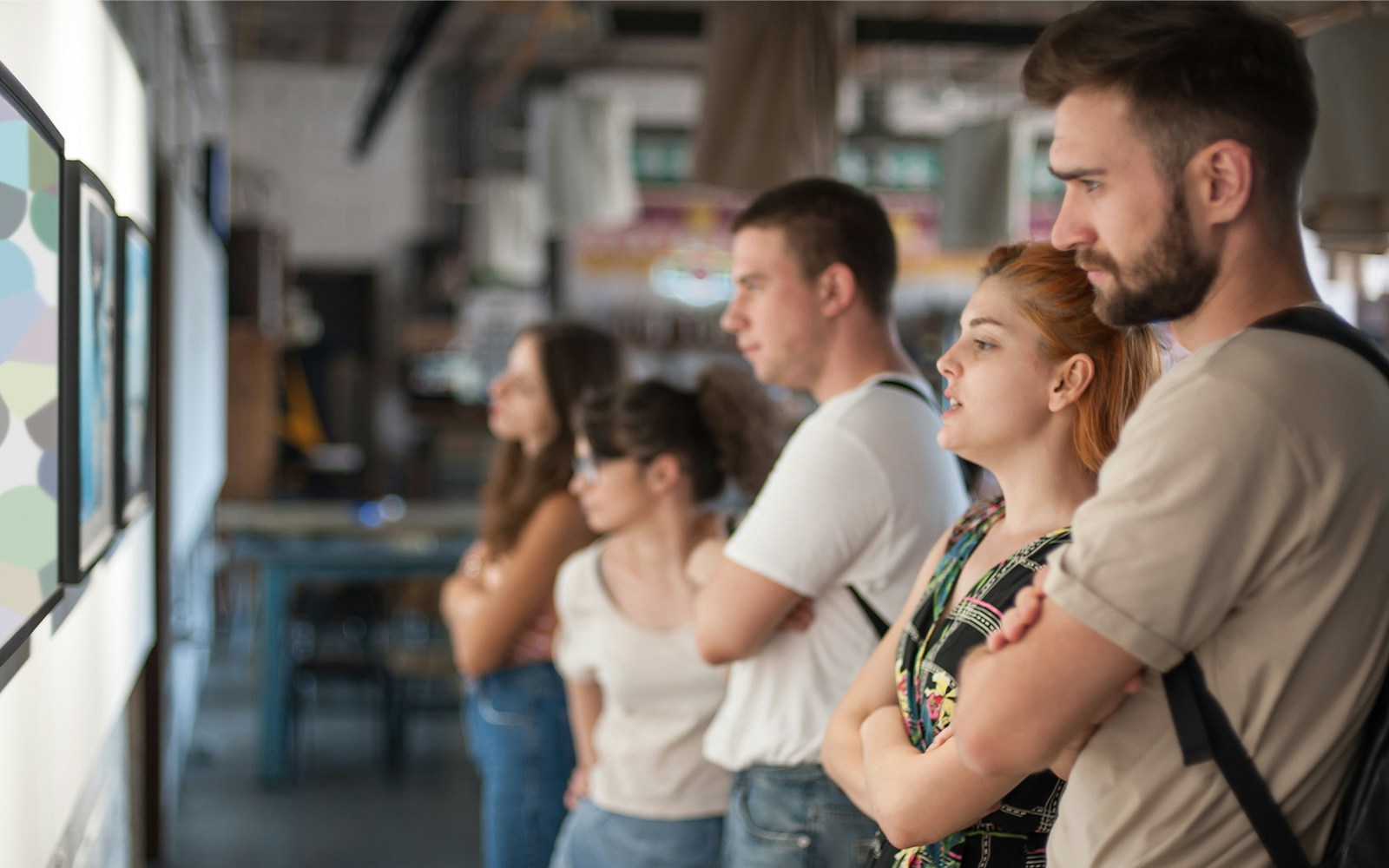 Visitors observing artwork in a modern gallery setting.