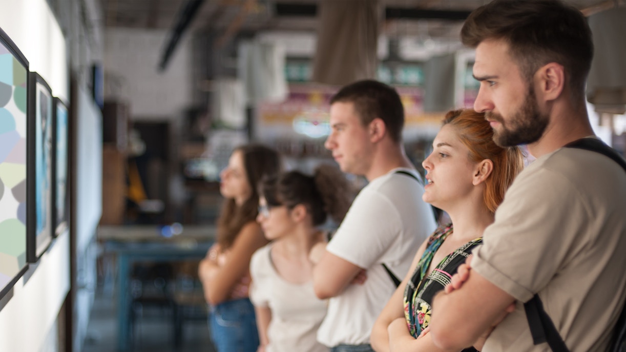 Visitors observing artwork in a modern gallery setting.