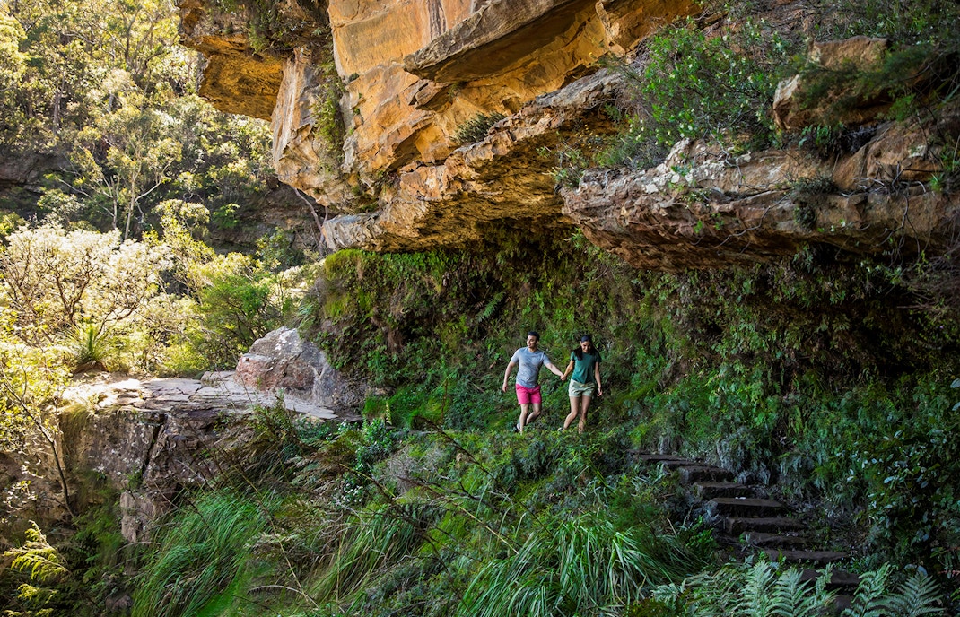 Couple walking on secluded bush trail during Blue Mountains Sunset & Wilderness Day Trip from Sydney.