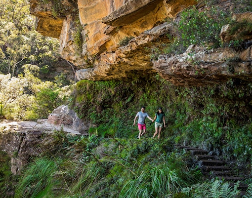 Couple walking on secluded bush trail during Blue Mountains Sunset & Wilderness Day Trip from Sydney.