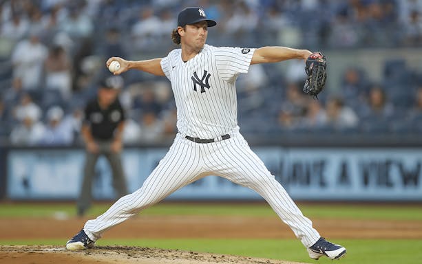 Pitcher in New York Yankees uniform throwing a pitch during game against Detroit Tigers.
