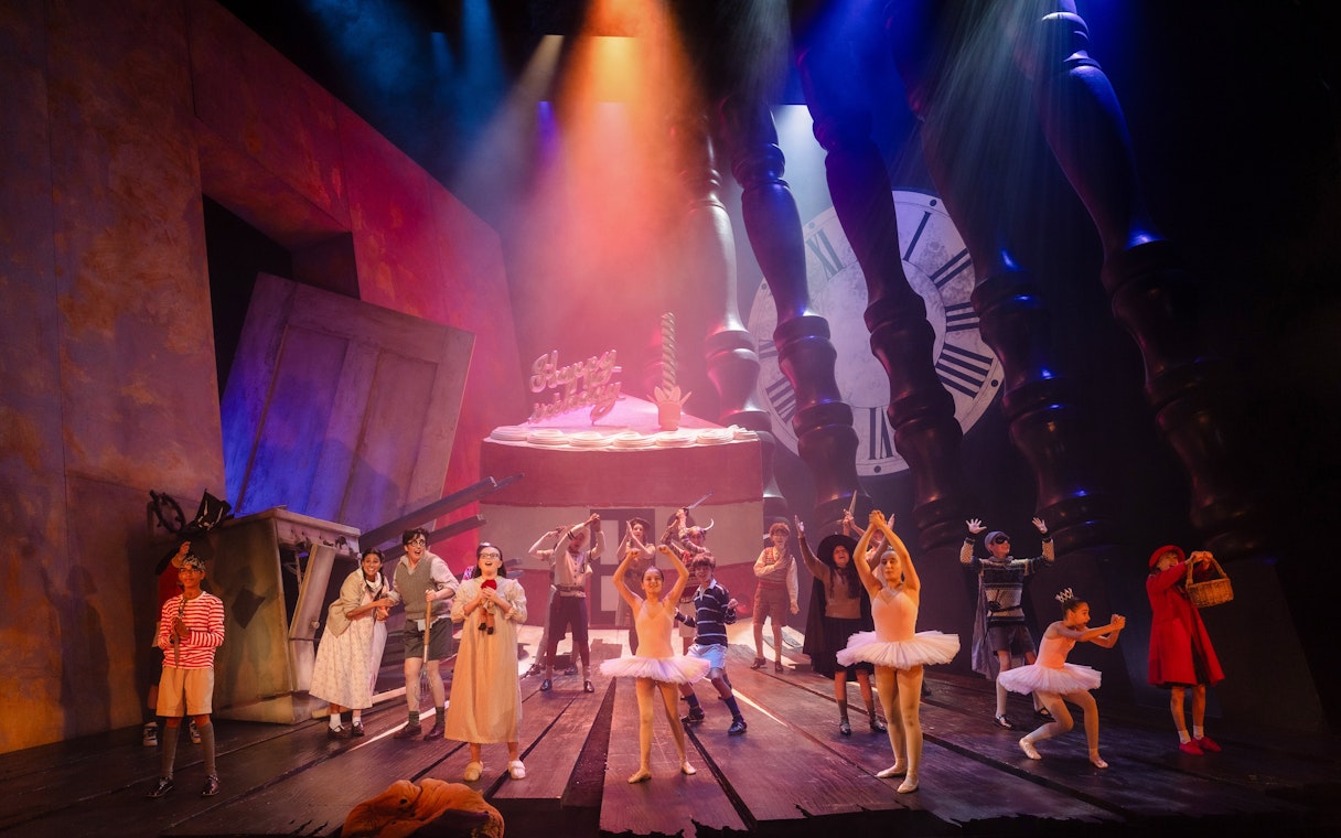 Stage performance of Hansel and Gretel with dancers and oversized props.