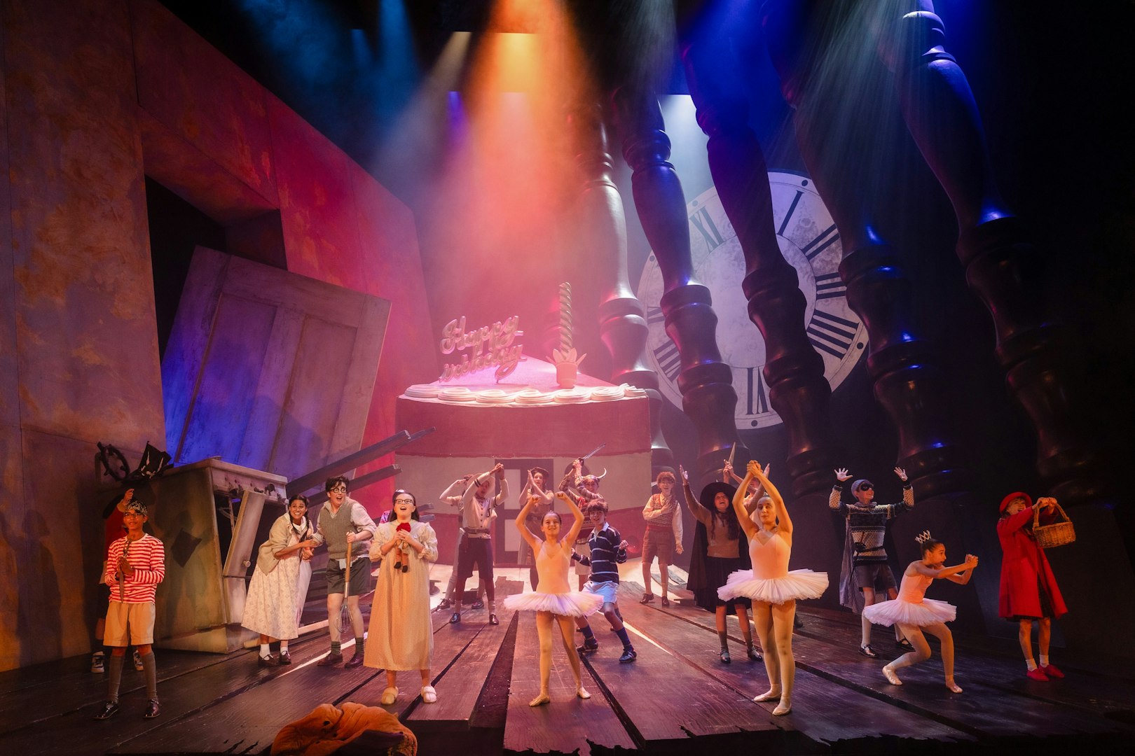 Stage performance of Hansel and Gretel with dancers and oversized props.