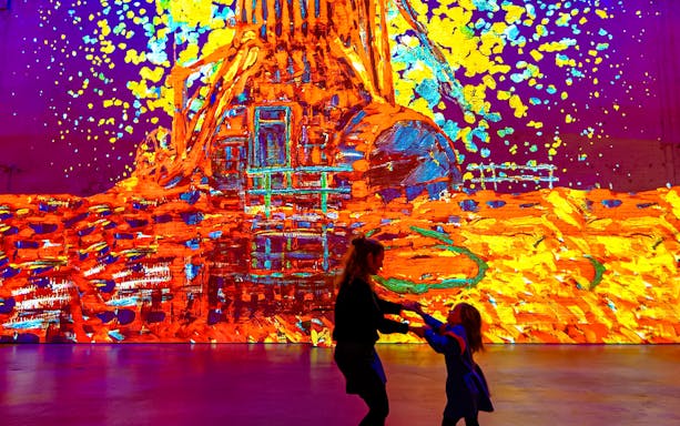 Visitors enjoying vibrant digital art display at Fabrique des Lumières.