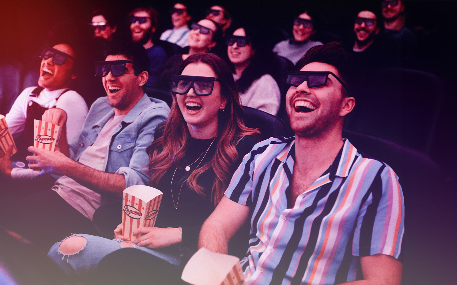 Group enjoying a 3D movie experience with popcorn in a theater.