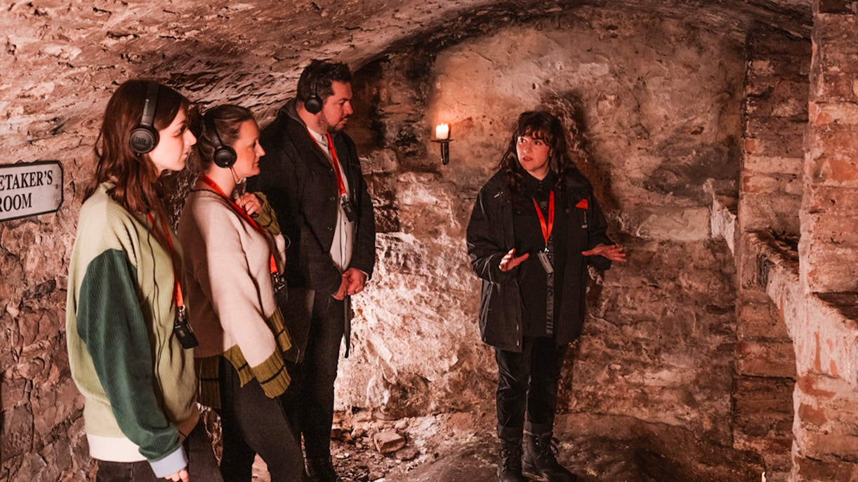 Guide explaining to guests in historic underground vaults tour.