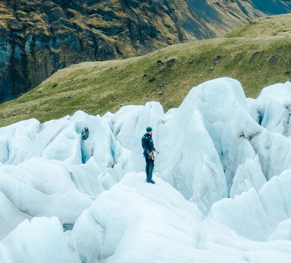 Explorer navigating ice formations in Skaftafell, Iceland.