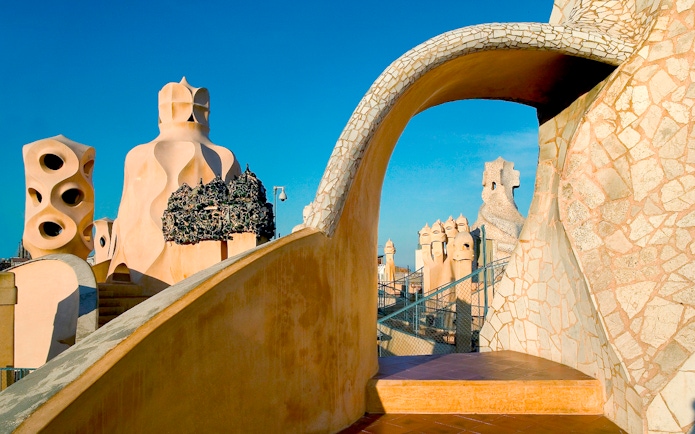 Rooftop chimneys of La Pedrera, Casa Mila in Barcelona, showcasing unique architectural design.
