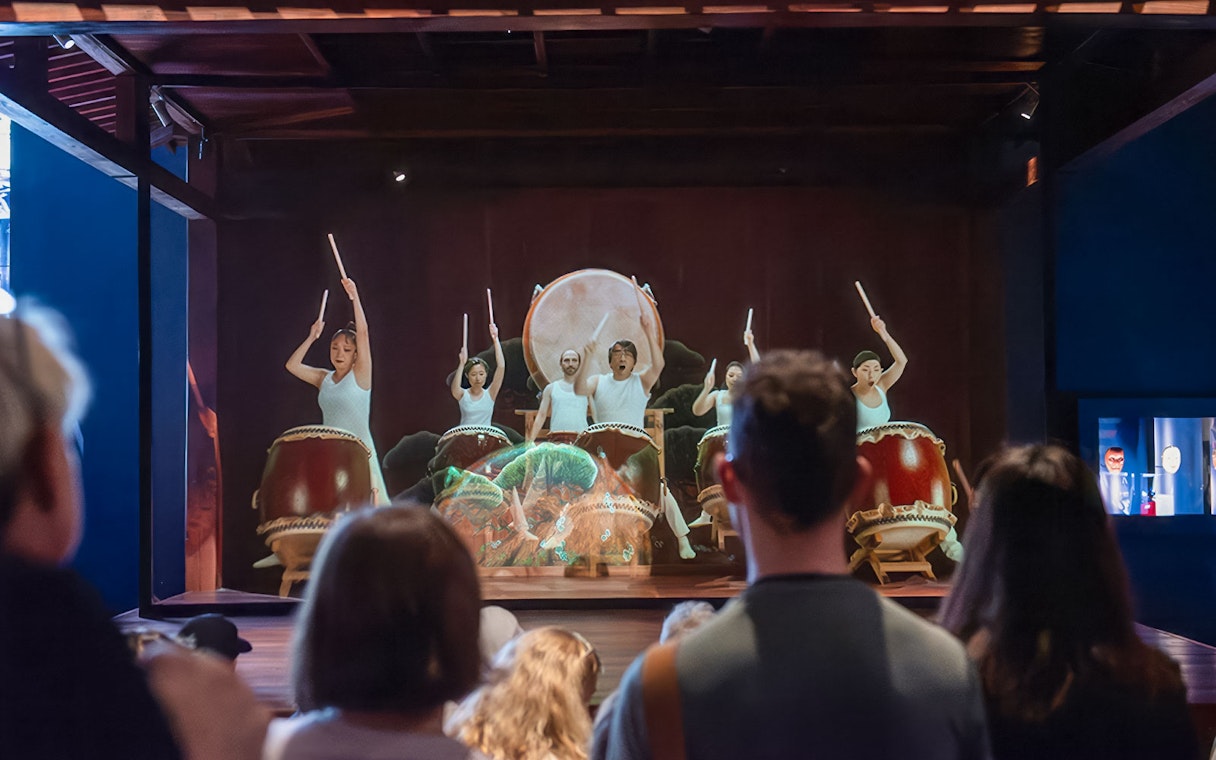 Taiko drummers performing at Samurai Museum, engaging audience in cultural experience.