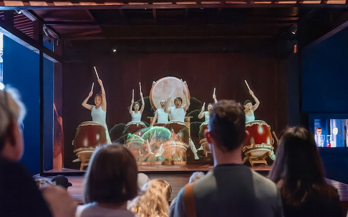 Taiko drummers performing at Samurai Museum, engaging audience in cultural experience.
