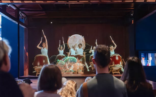 Taiko drummers performing at Samurai Museum, engaging audience in cultural experience.