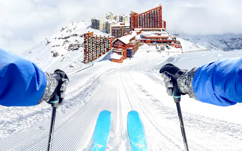 Skiing down a snowy slope towards Valle Nevado resort, Santiago.