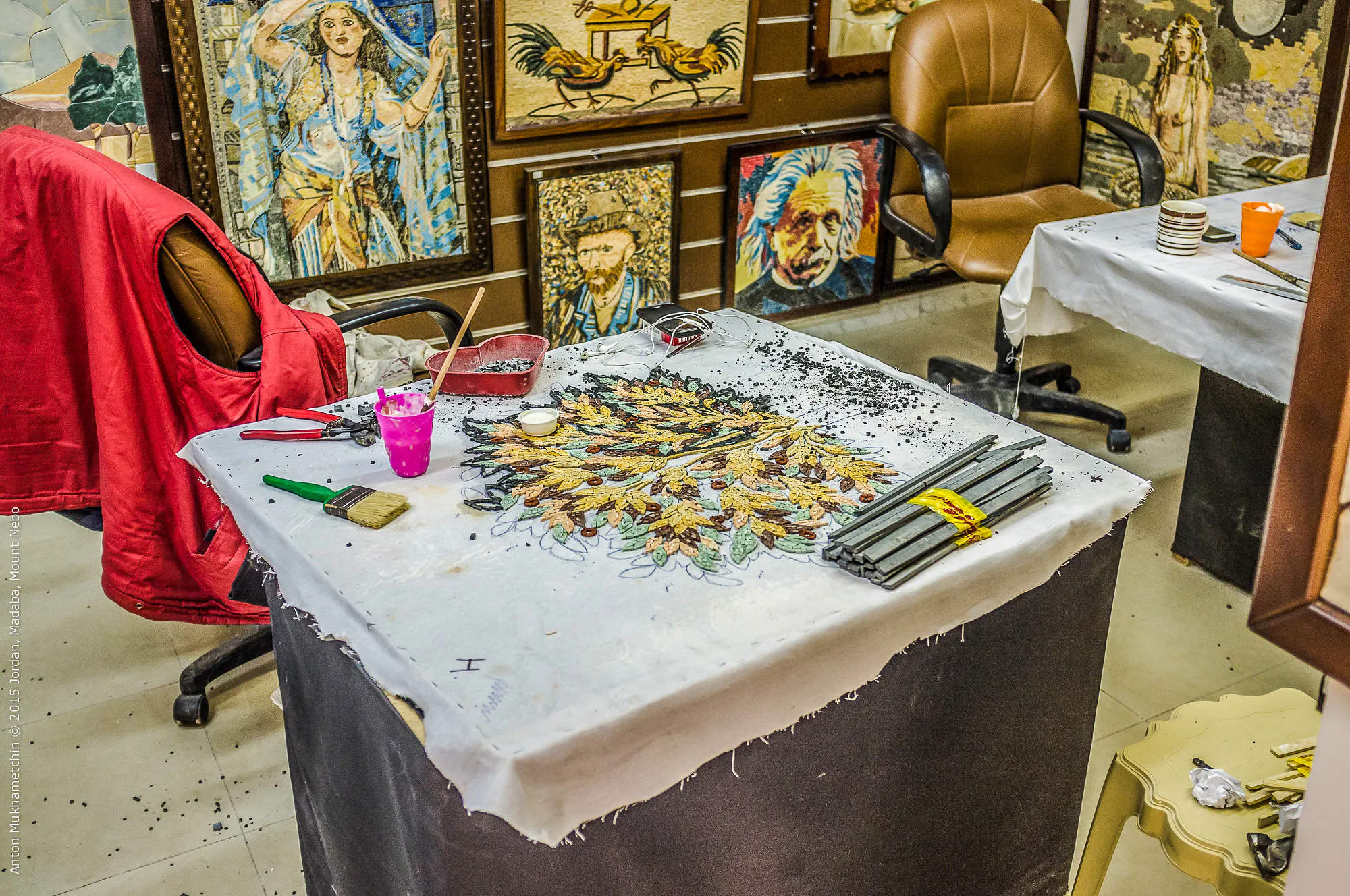 Mosaic art workshop in Madaba, featuring tools and artwork in progress.