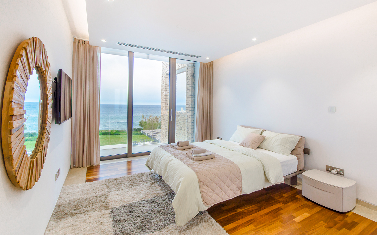 Ocean view hotel room with balcony overlooking the sea in a coastal city.