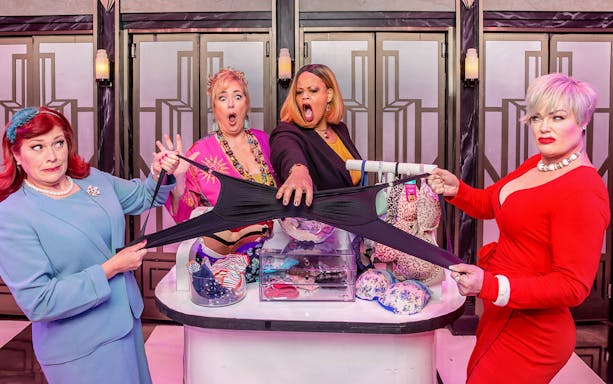 Women in a comedic scene from Menopause the Musical, holding oversized underwear.