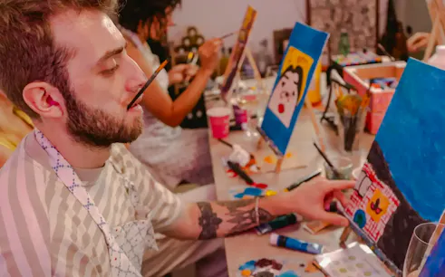 Art class participant painting with wine and snacks in Rome.