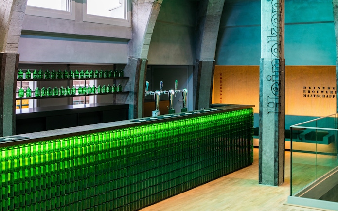 Heineken bar with green bottles and taps at rooftop experience in Amsterdam.