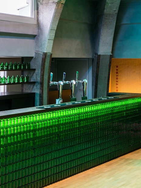 Heineken bar with green bottles and taps at rooftop experience in Amsterdam.