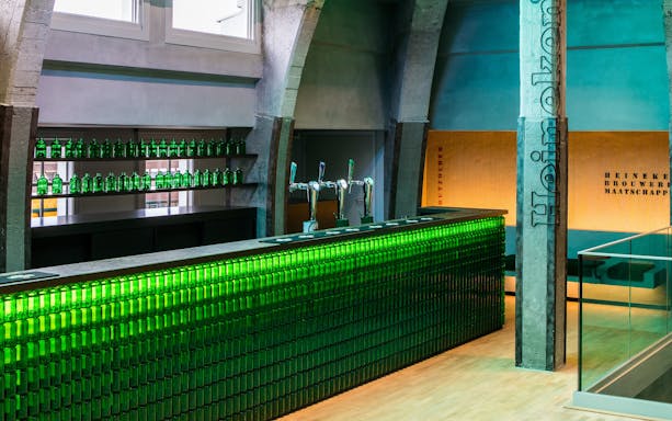Heineken bar with green bottles and taps at rooftop experience in Amsterdam.