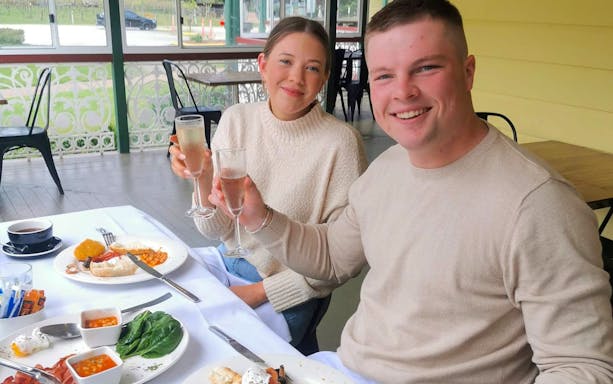 Couple enjoying champagne breakfast at a vineyard in Brisbane.