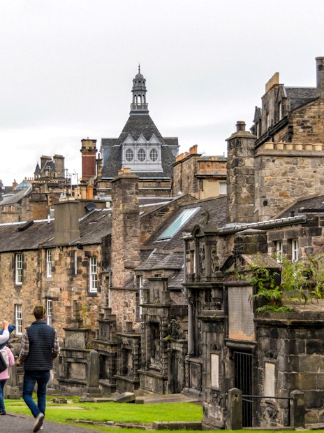 Tourists walking through historic Edinburgh street on Harry Potter walking tour.