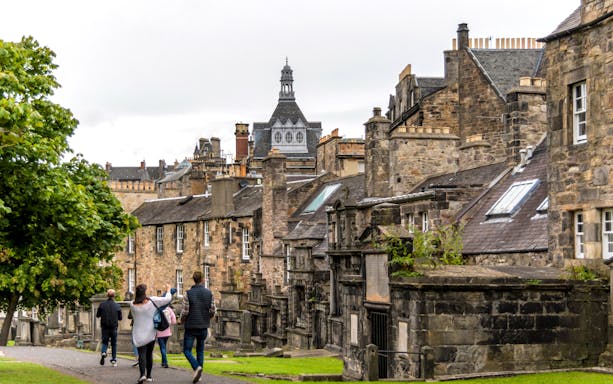 Tourists walking through historic Edinburgh street on Harry Potter walking tour.