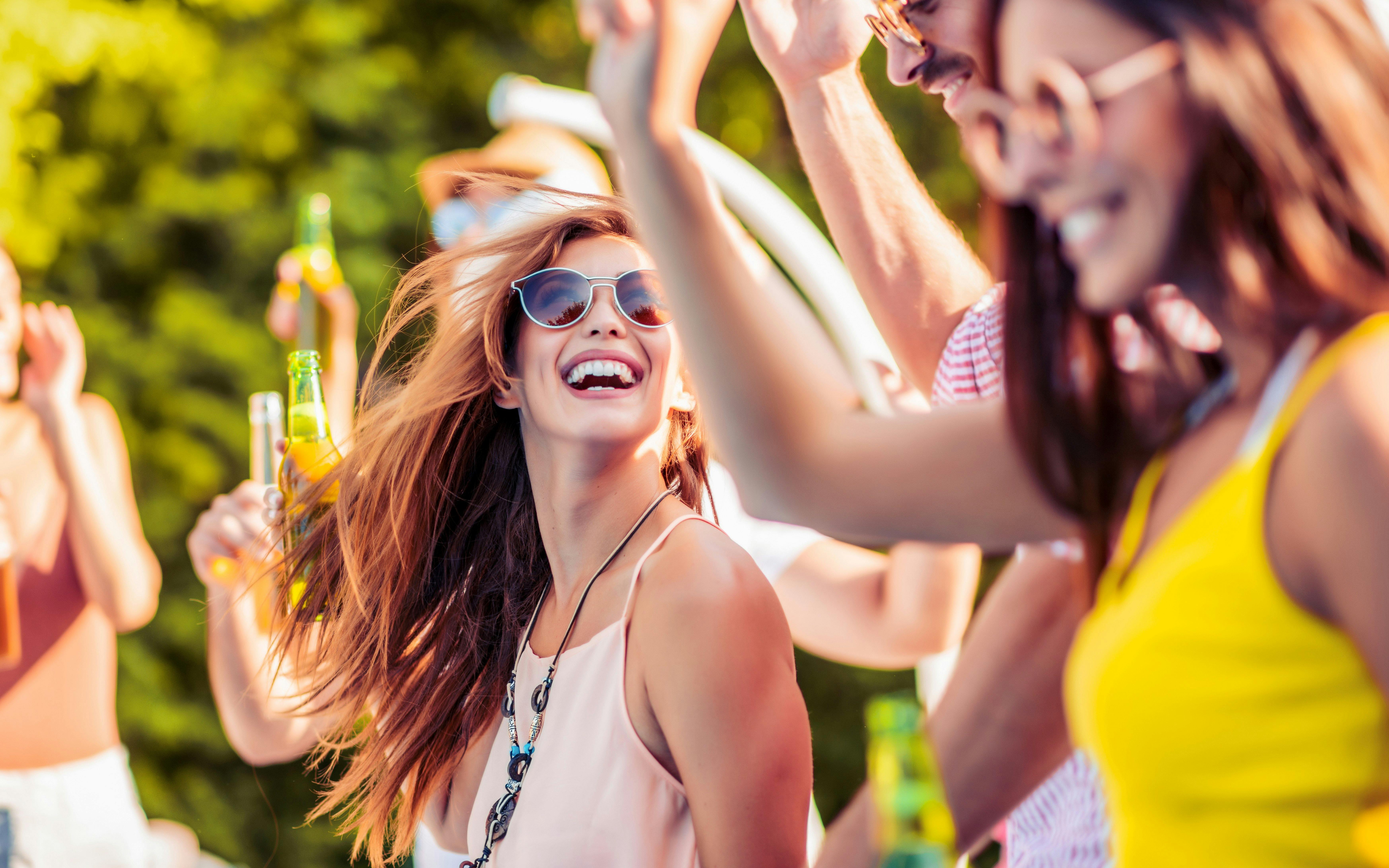 Friends enjoying a daytime outdoor party with drinks and laughter.