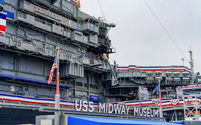 USS Midway Museum exterior with American flags and naval decorations.