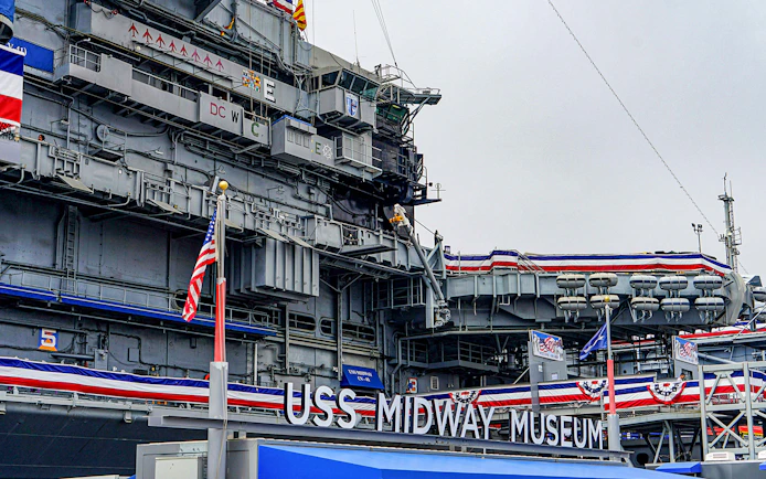 USS Midway Museum exterior with American flags and naval decorations.