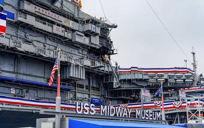 USS Midway Museum exterior with American flags and naval decorations.