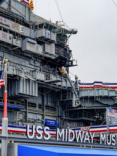 USS Midway Museum exterior with American flags and naval decorations.